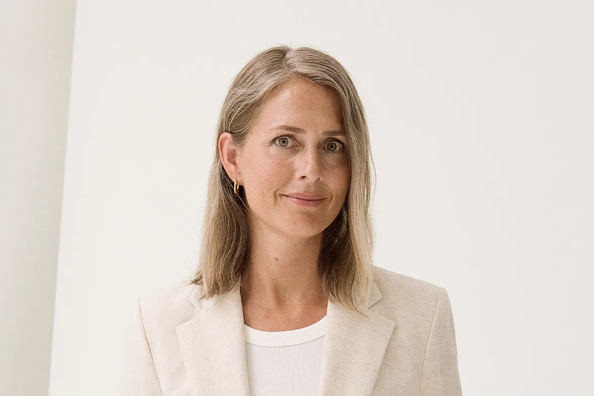 A woman smiling professionally in a formal setting-a public figure.
